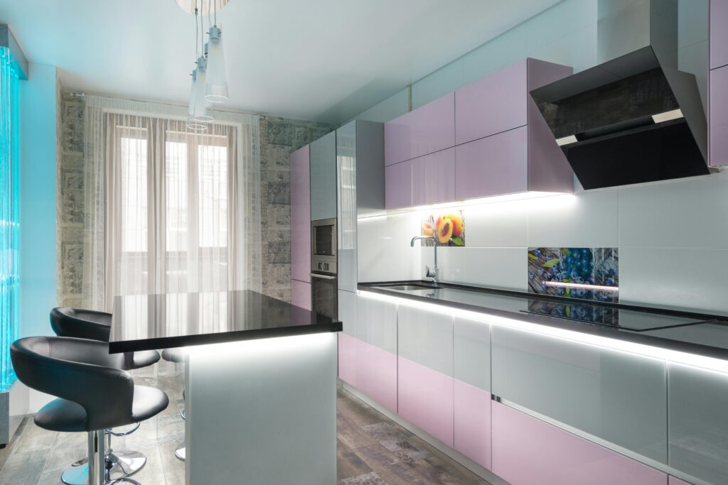 Stylish modern kitchen interior featuring glossy pink cabinets and a sleek design.